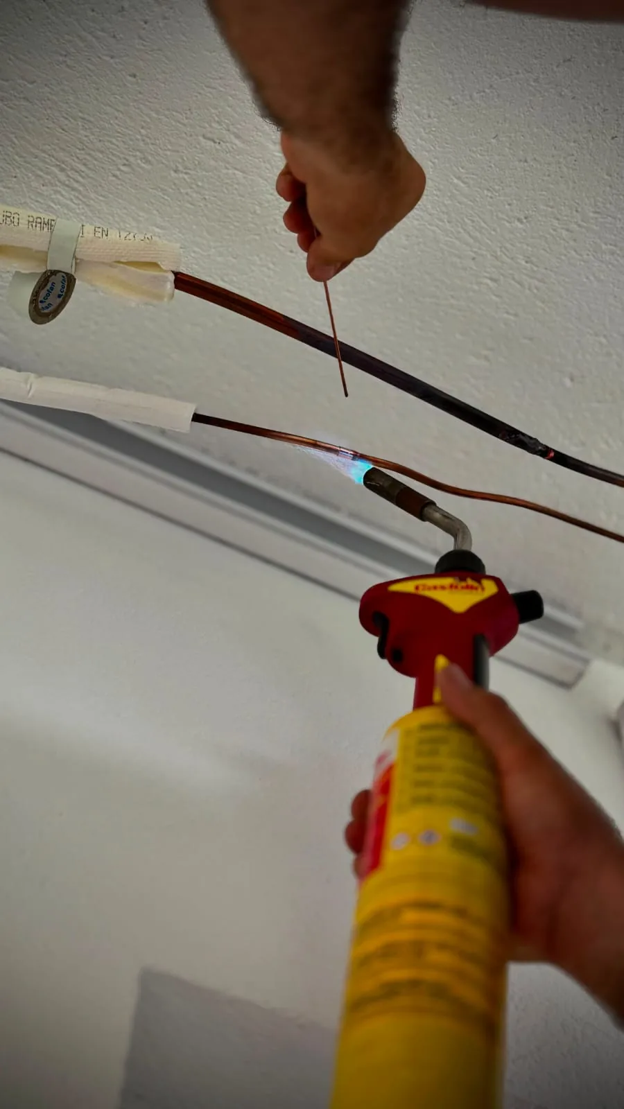 Technician brazing the copper pipework during an air conditioning installation.